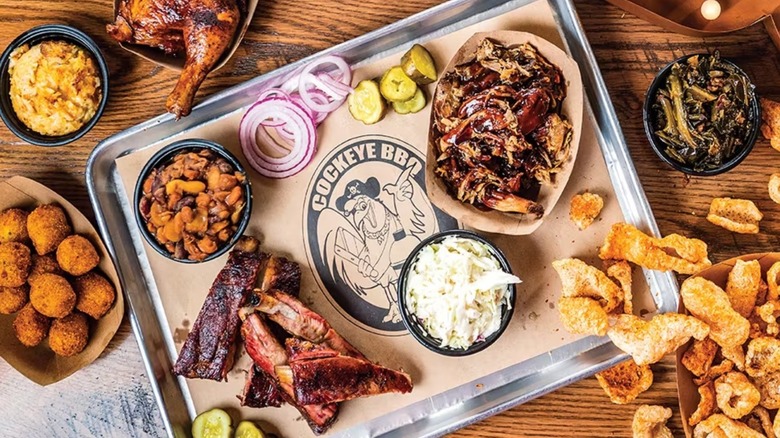 Tray of BBQ meats, sides, slaw, onions, and pickles
