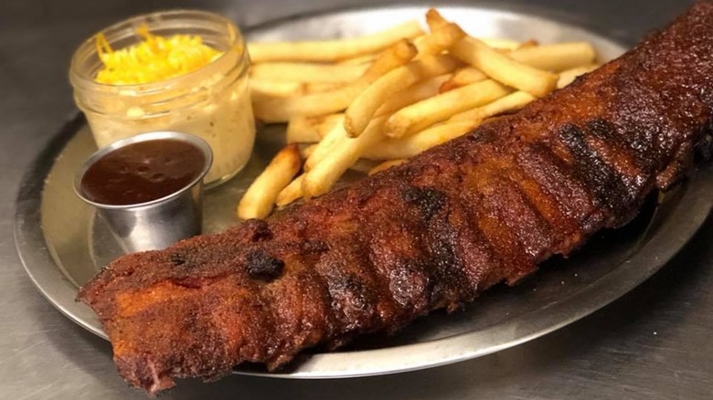 Rack of ribs on a steel tray with fries