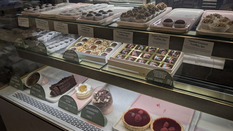 Truffles and other chocolate desserts in glass display case