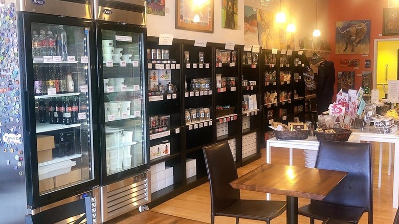 Various chocolate products in refrigerator and on shelves, with a few small tables for dining