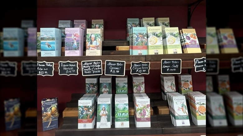 Chocolate bars of various flavors on shelves, with cards describing tasting notes for each
