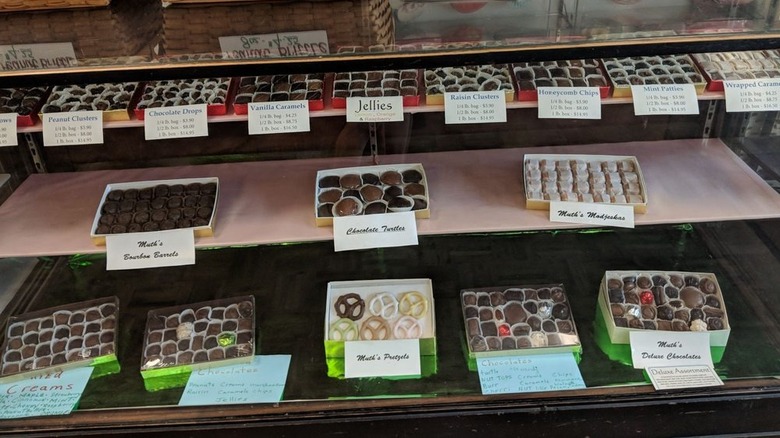 Various chocolate confections in glass display case, including modjeskas and bourbon barrels