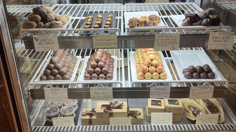 Various chocolate confections like Date Poppers and Peanut Butter Turkish Figs in glass display case