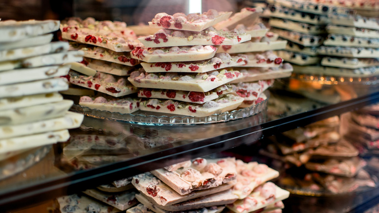 Chocolate bark in various flavors behind glass display case