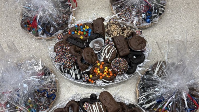 Several platters with various chocolate confections, some wrapped in plastic
