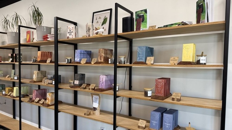 Shelves stocked with several flavors of chocolate bars, each one accompanied by samples