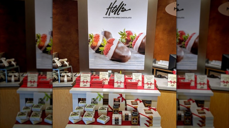 Advertisement for double dipped strawberries above shelves laden with chocolate products