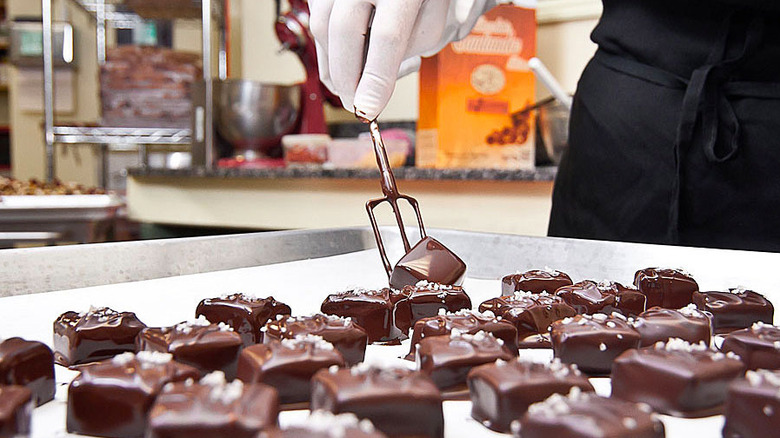 Chocolatier preparing dark chocolate caramels sprinkled with fleur de sel