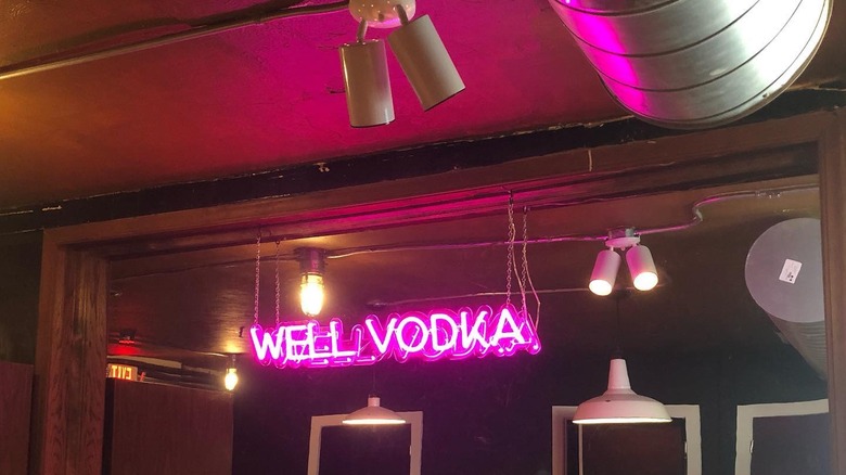 Neon "Well Vodka" sign with industrial-style lighting at Charlie's Star Lounge