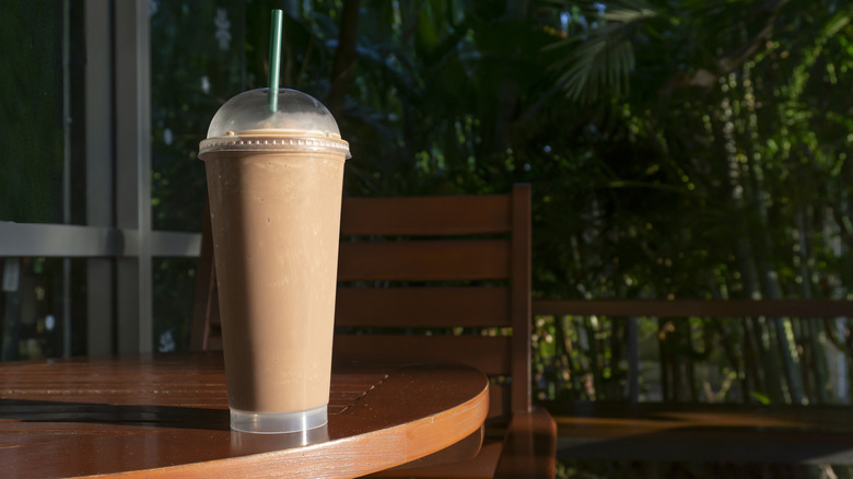 Chocolate milkshake sitting on a table outside