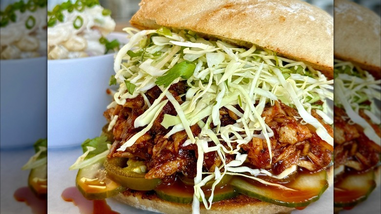 Thick fish sandwich with shredded lettuce, pickles, jalapeño on bun