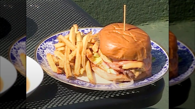 Fish sandwich and fries on blue plate