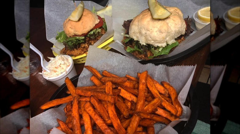 Sweet potato fries in basket in front of two fish sandwiches