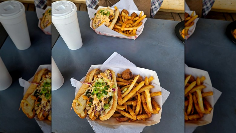 Fish po'boy next to fries in basket