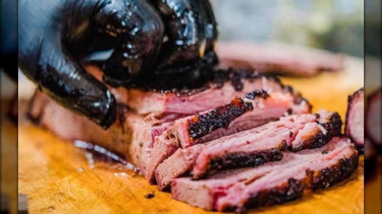 Glaved hand with sliced brisket