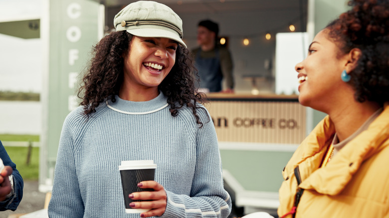 Two people getting coffee from a food truck