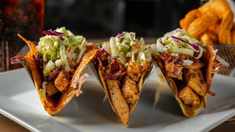 Three tacos with slaw on a plate