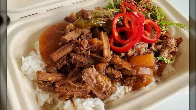 Braised beef and veg over rice in container