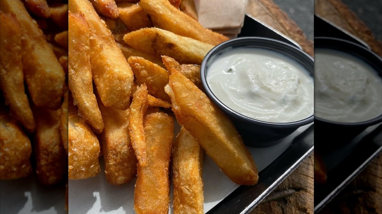 Fries from Wurstkuche next to white sauce on metal tray
