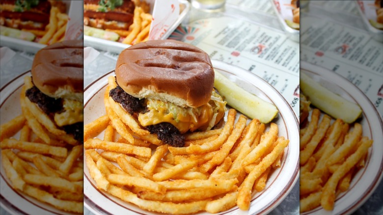 Plate with cheeseburger, pickle spear, and fries