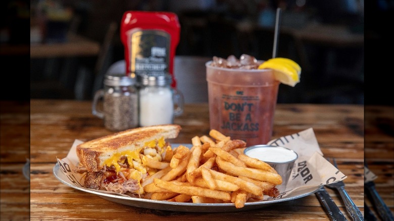Plate of grilled cheese and fries on wooden table