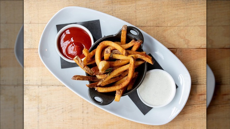 Top-down shot of fries and ketchup on white plate