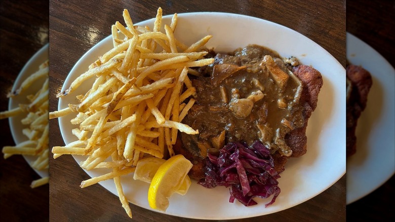 Schnitzel and shoestring fries on white plate