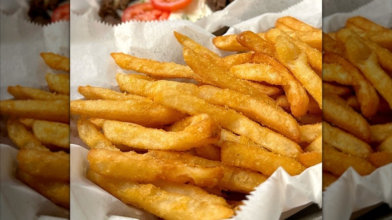 Close-up of crispy fries in white paper