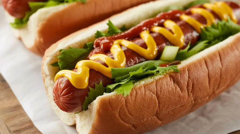 A closeup of a hot dog on a fluffy bun with toppings