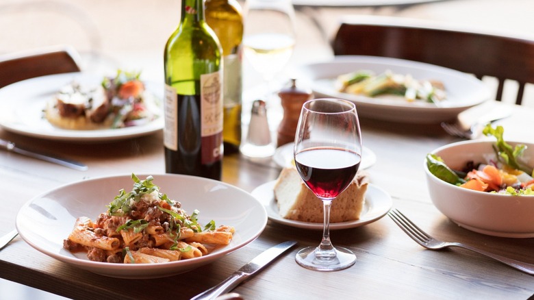 Table set with assorted Italian dishes and wine with glass and bottle