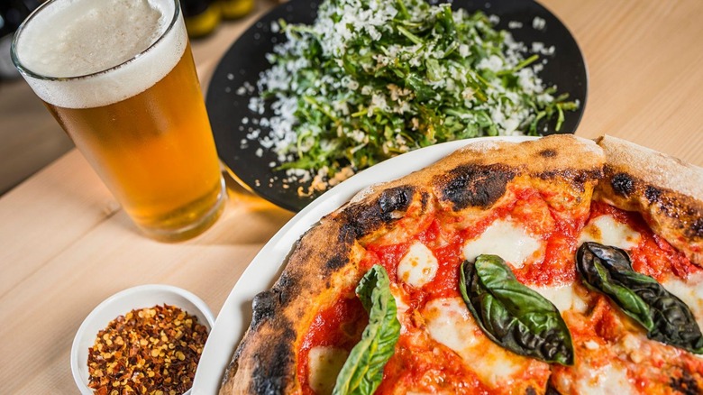 Wood-fired pizza with beer and salad