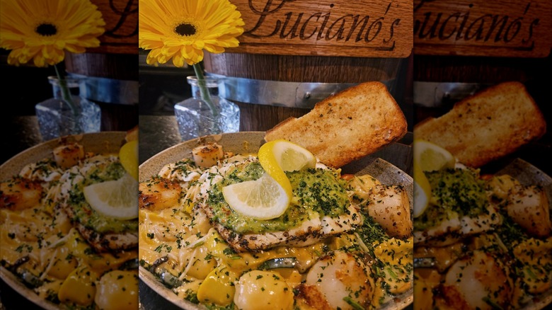 Halibut and scallop gnocchi beside Luciano's wooden sign