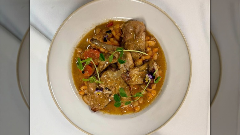 Braised rabbit with white bean ragi on white plate