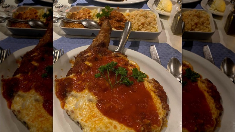 Veal parmesan on table with other dishes in background