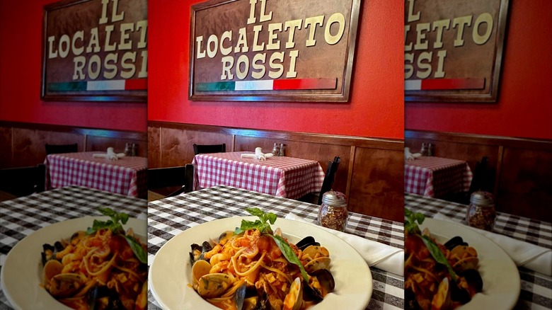 Pasta and mussels on table with Il Localetto Rossi sign on the wall