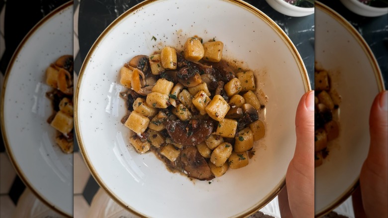 Gnocchi and mushroom dish in white bowl