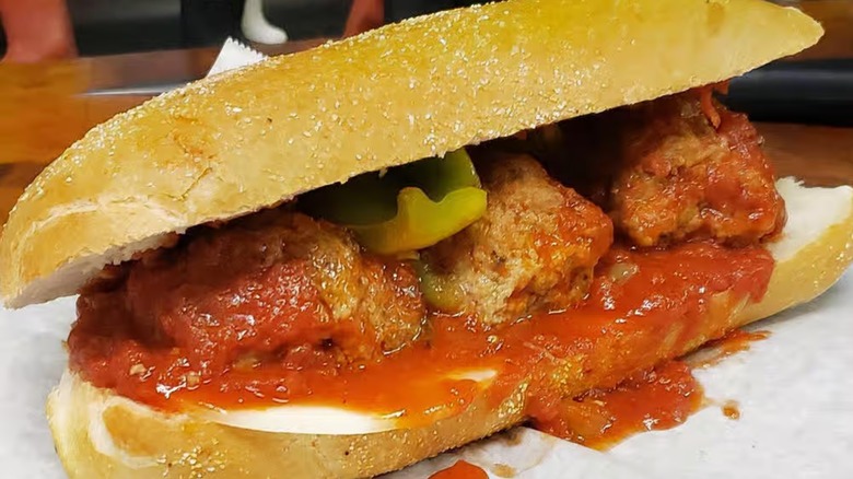 Meatball sub with peppers on white paper wrap