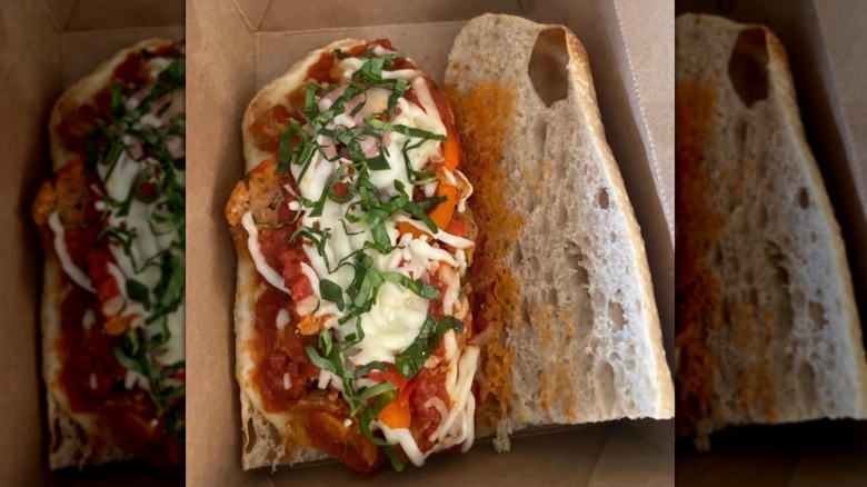 Open meatball sub with sauce and melted cheese on silver tray