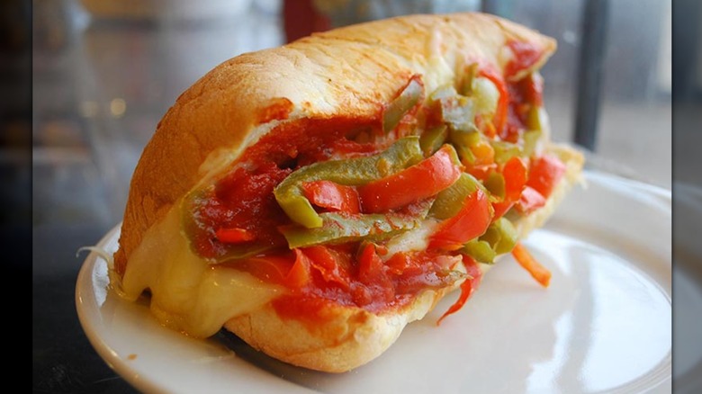 Meatball sub with peppers on white plate