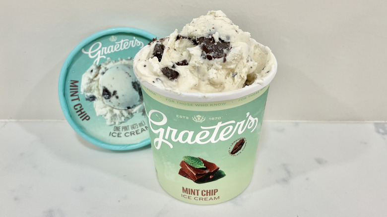 A pint of Graeter's Mint Chip ice cream with the top removed on a white stone countertop