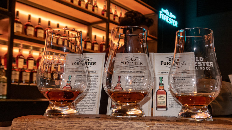 bottles of Old Forester whiskey with tasting glasses
