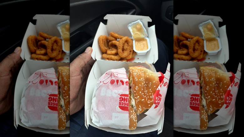 Burger King burger off broiler with fried onion rings in burger container