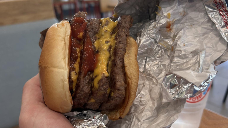 Hand holding a Wendy's meat cube in wrapper