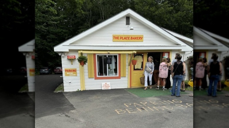 The outside of The Place Bakery with people standing in a line out the door.