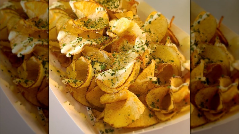 Sliced and fried potatoes with seasoning in tray