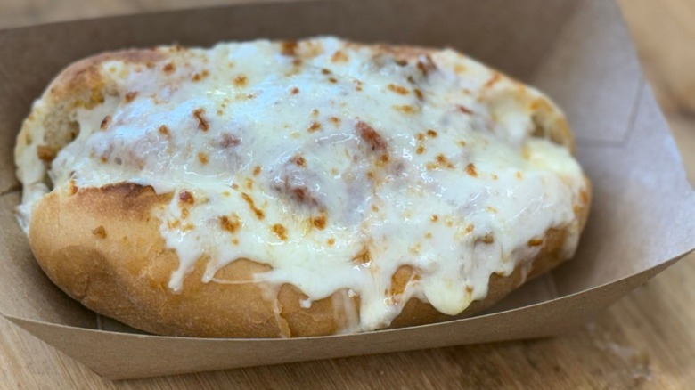 Cheese-covered Gizmo sandwich on bun in cardboard tray