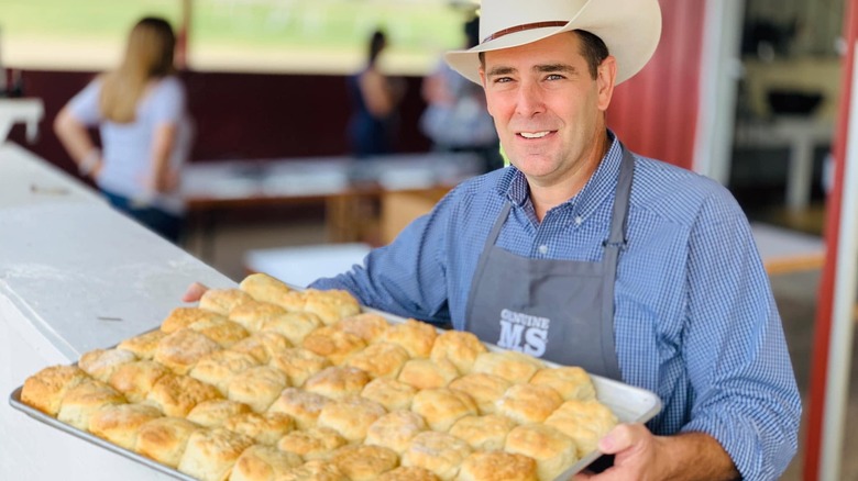 Man holding a tray of buttermilk biscuits
