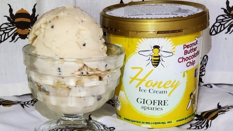 Container of honey ice cream with dish