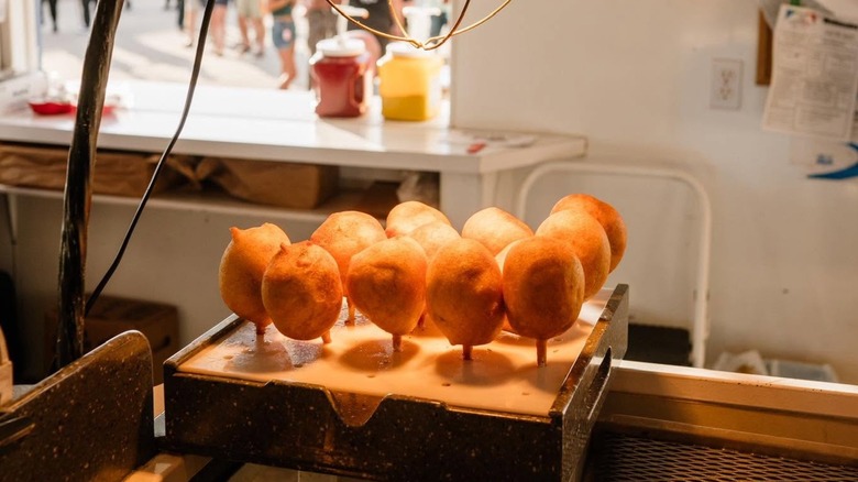 Battered and fried meatballs on sticks in kitchen of fair stand
