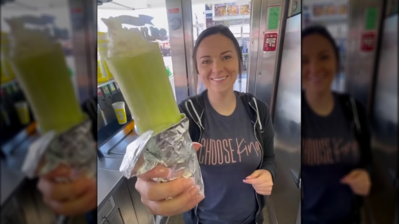 Smiling woman holding stuffed cucumber